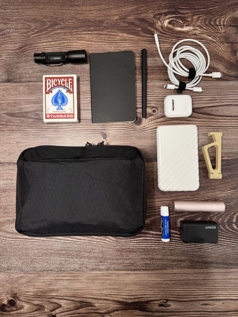 A look inside the Tech Pouch, fully loaded with gear. The clear pocket layout and center zip pocket keep your essentials neatly organized and easily accessible.